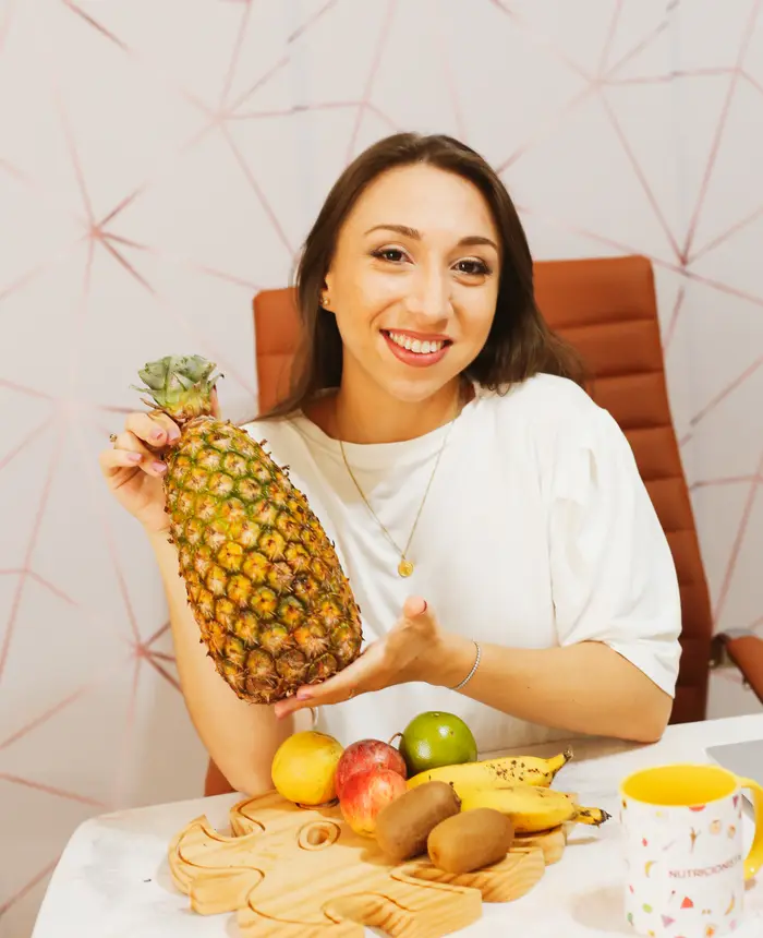 Raquel Mendes com um abacaxi e frutas